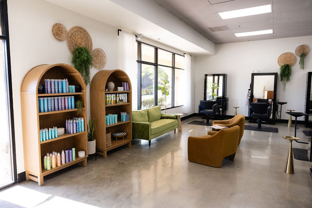 Salon Thrive interior lounge with arched shelving and retail products